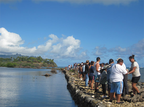Figure 3. Volunteers help rebuild the fishpond wall