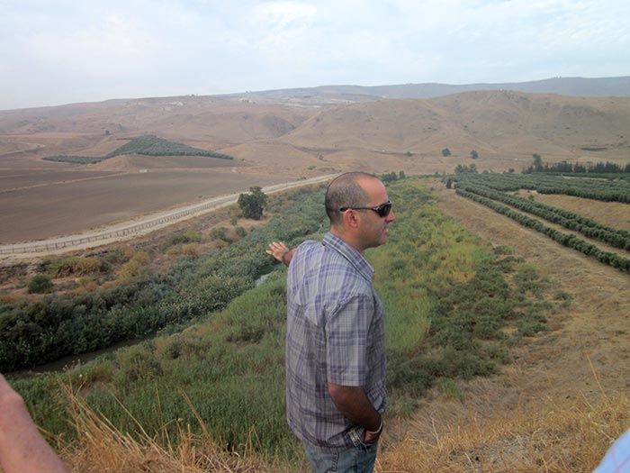 Hagai Oz showing what has become of the Jordan river to a German tour group visiting the Peace Island.